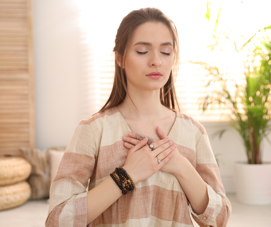 Une femme pose la main sur son cœur pour apprendre à s'aimer