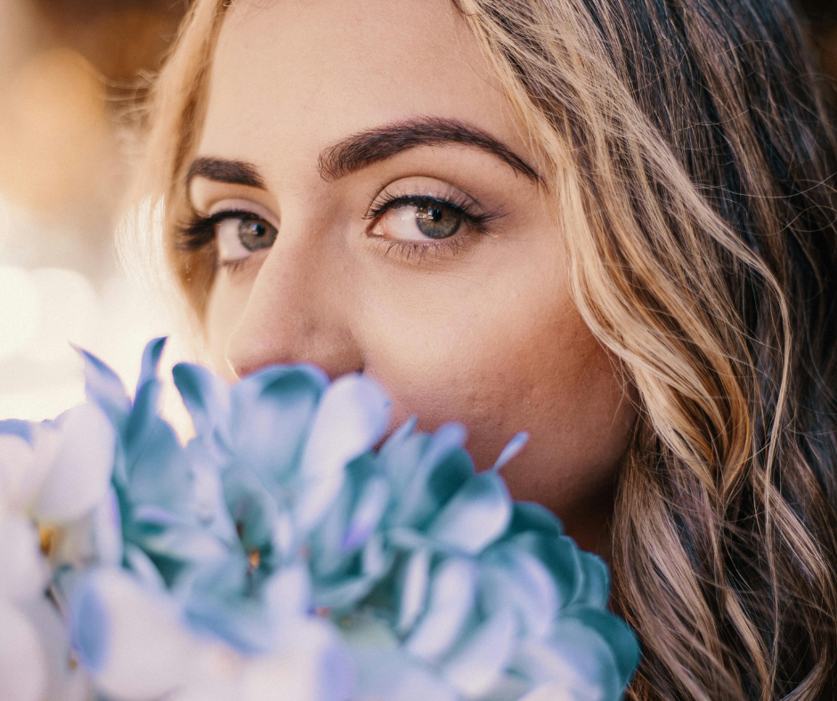 Une femme avec des fleurs devant le visage apprend à se faire confiance malgré ses doutes